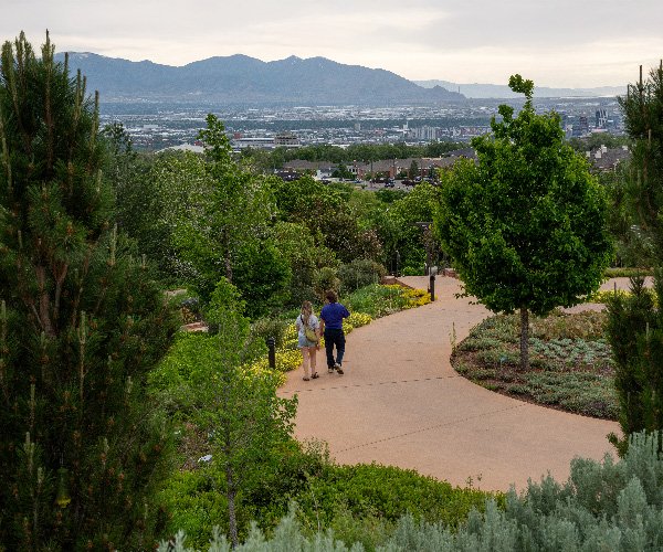 Couple walking in Red Butte Garden with a view of Salt Lake City
