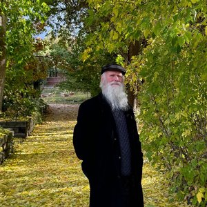 James Batton standing on a leaf-lined path