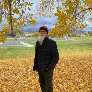 James Batton in autumn leaves with mountains in the background