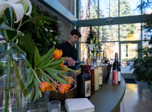 A bartender prepares a beverage at a Gala in the Red Butte Garden Orangerie.